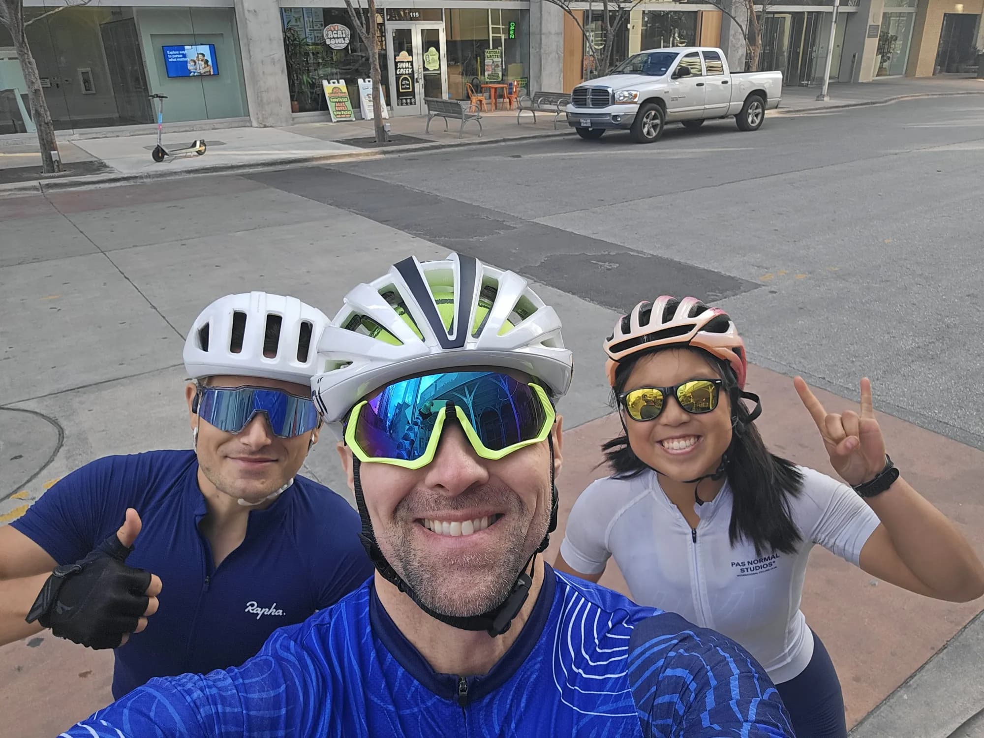Carey Rouse with two riders in cycling kit on a downtown Austin street