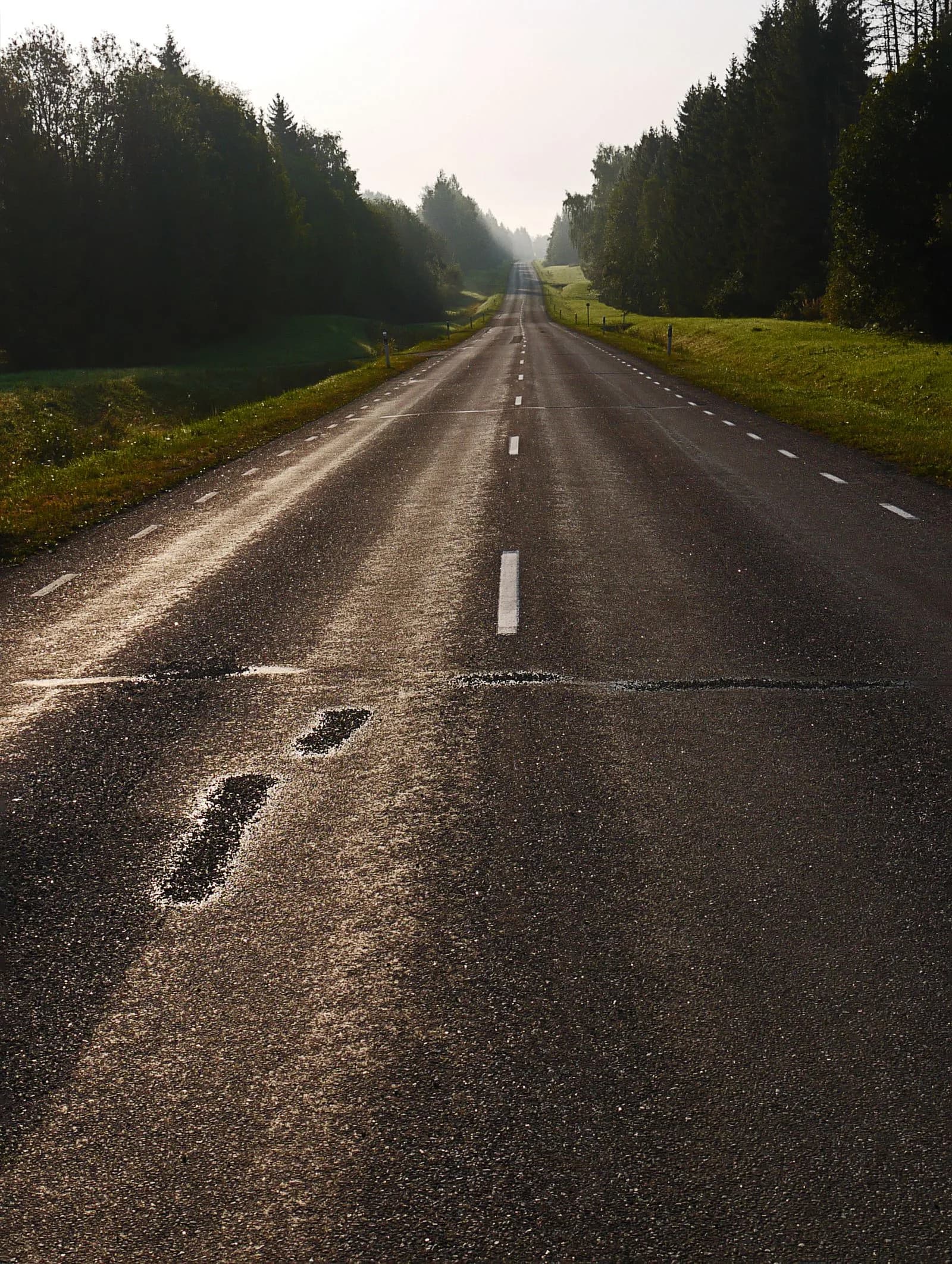 A rider climbing a paved mountain road alone on a long day in the saddle