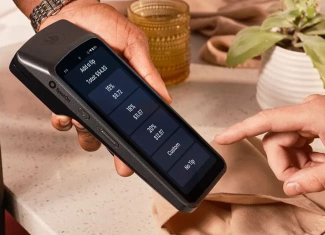 A payment terminal at a restaurant table asking the guest to choose a tip percentage