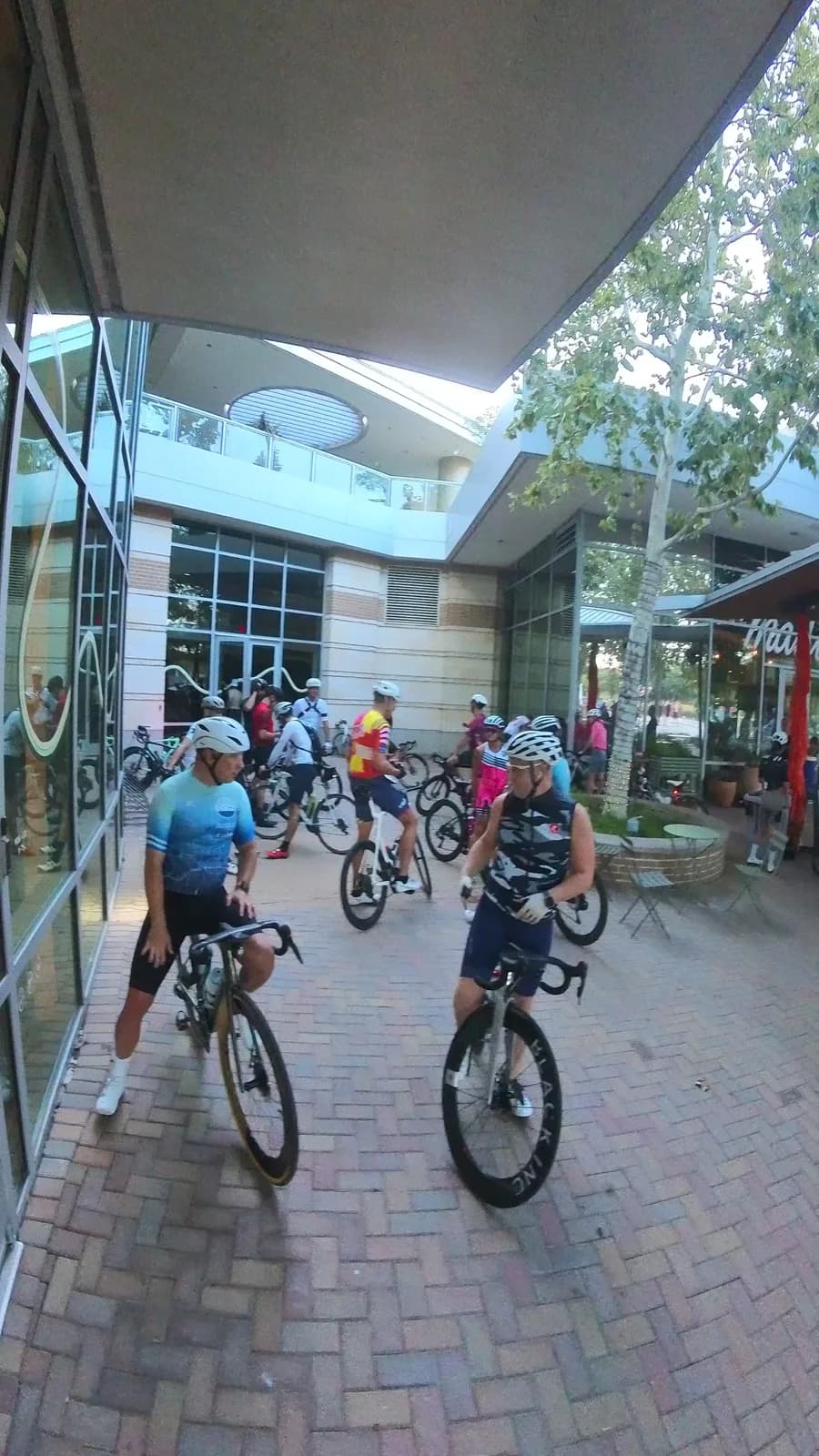 Two riders talking on the brick plaza before a morning ride