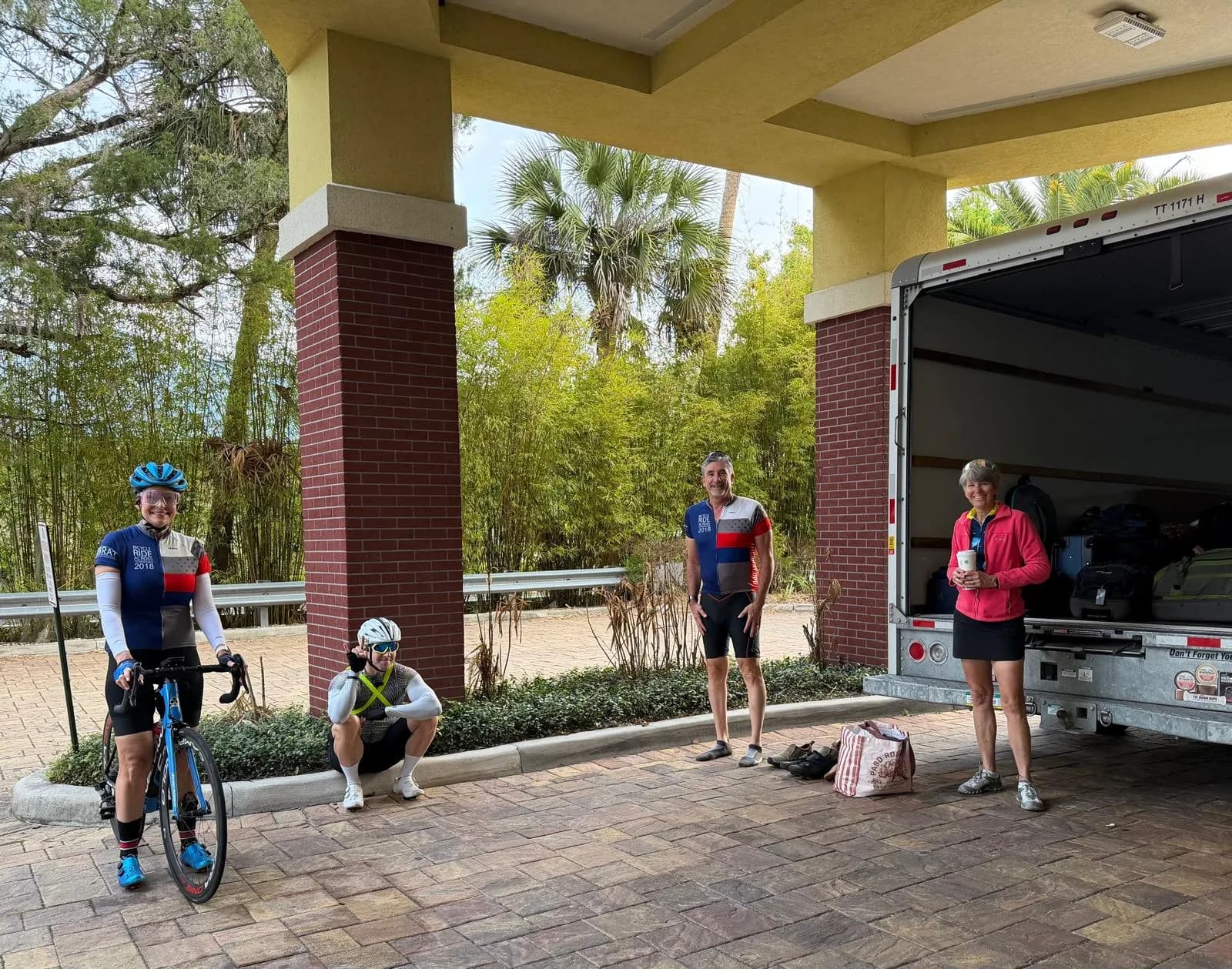Coffee stop under the hotel portico, bikes and the support truck ready to roll