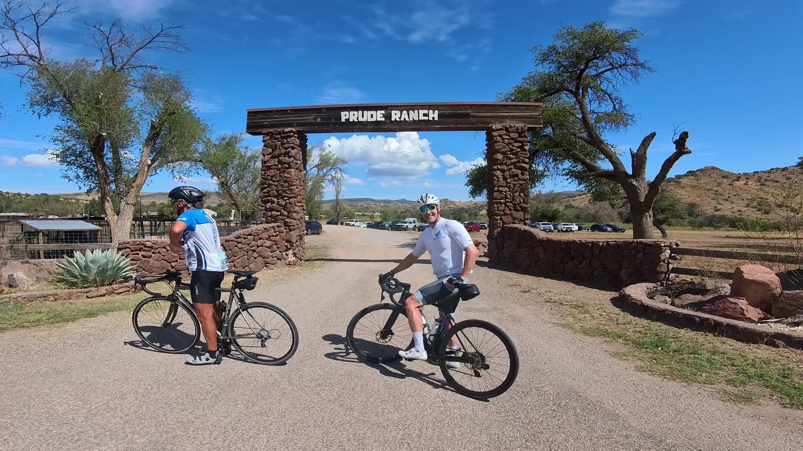 Two riders under the stone gateway arch of a West Texas ranch