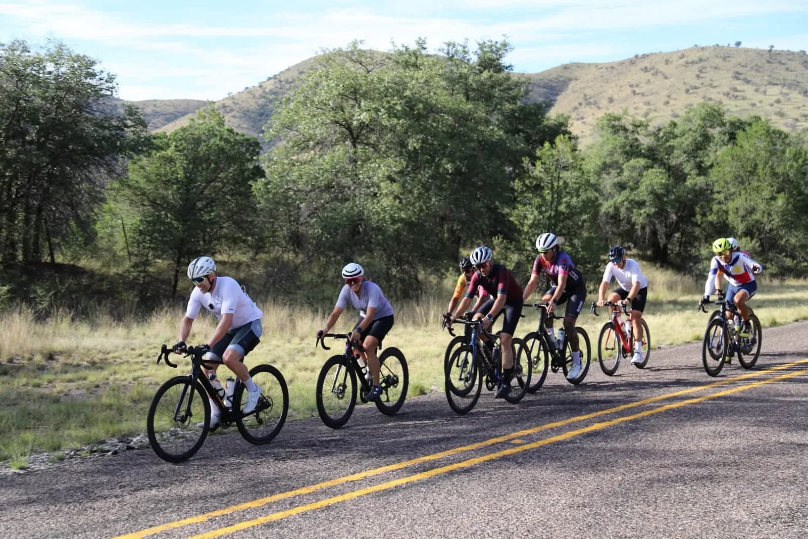 The group cresting a hill road between grassy slopes
